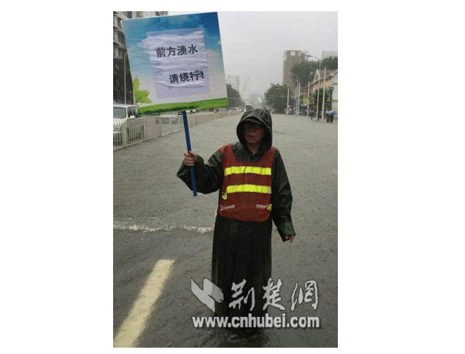 武汉环卫工雨中举牌8小时 提醒市民绕行_北京