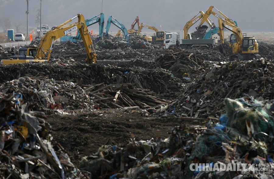 工人在日本福岛第一核电站附近浪江町清理海啸造成的废墟和受核污染