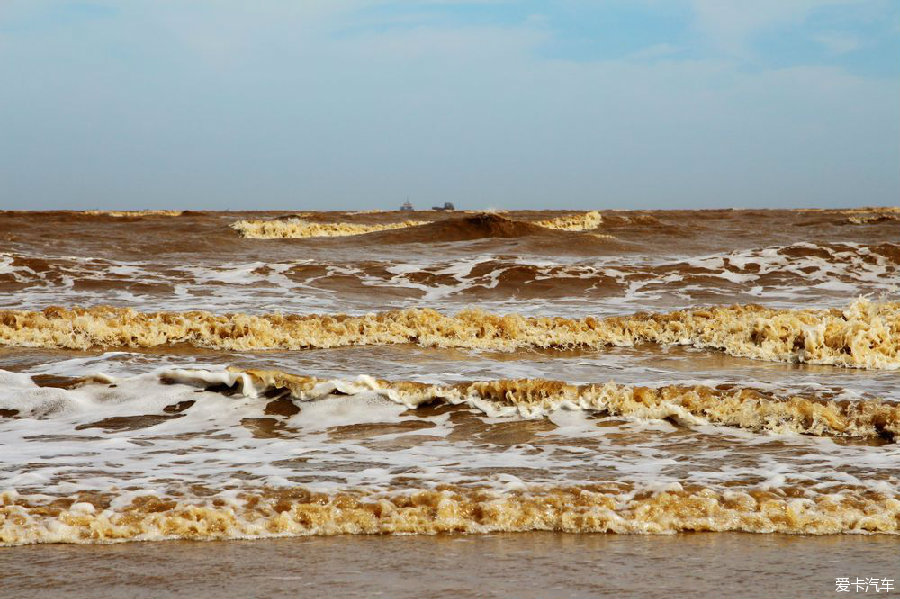 远方的两艘渔船,湄公河入海口的水是褐黄色的,裹挟着大量泥沙